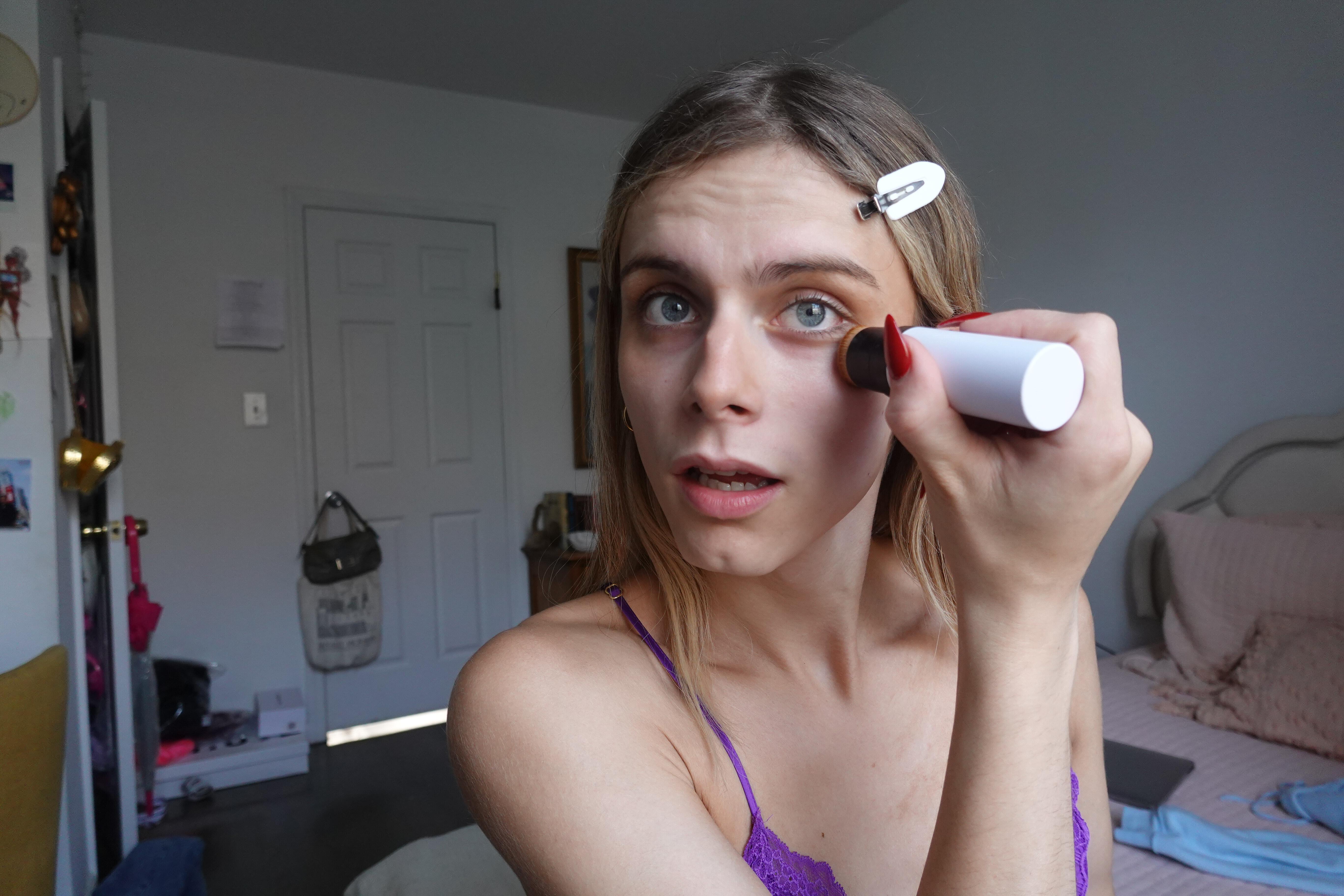blonde girl putting on makeup