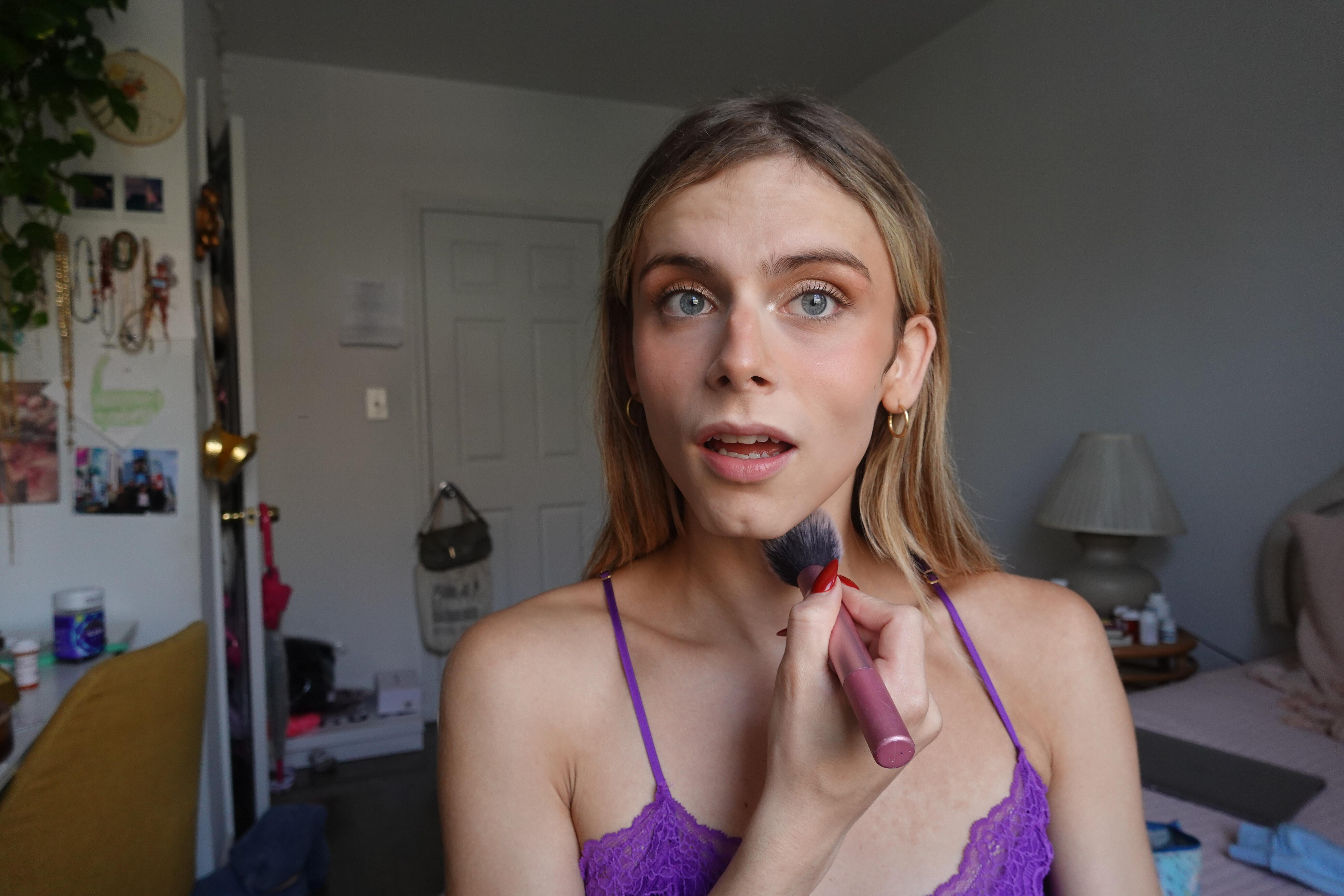 trans woman applying bronzer